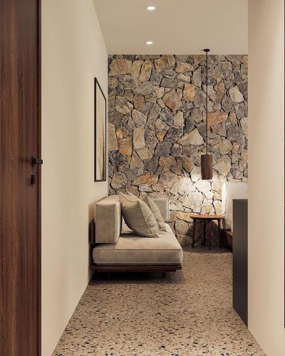 a living room with a couch and a stone wall at Thung Nham Resort in Ninh Binh