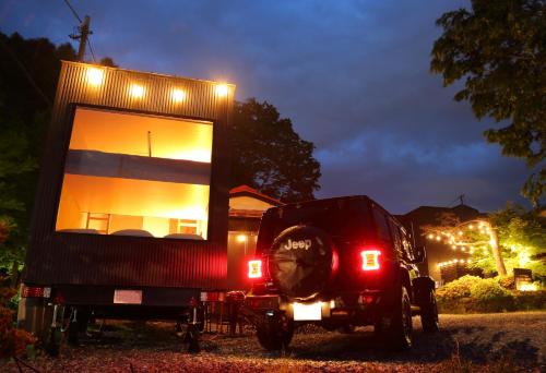 a tiny house on the back of a truck at night at Fuji Time Traveler BBQが楽しめる 河口湖湖畔すぐそば 6名宿泊可のトレーラーハウス in Azagawa