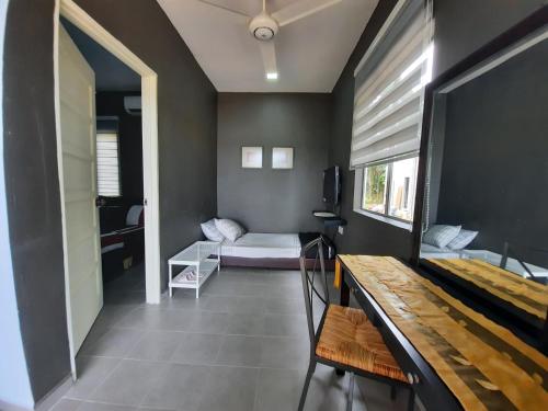 a room with a bedroom with a bed and a table at Rajawali Riverside Retreat in Dungun