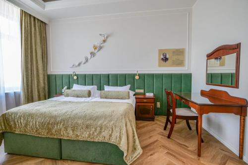 um quarto com uma cama e uma secretária. em Hotel Zlatá Hvězda em Litomysl