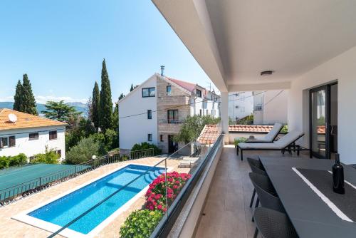 a view from the balcony of a house with a swimming pool at Maca Apartments & Suites in Trogir