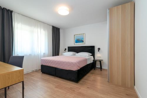 a bedroom with a bed and a desk in a room at Maca Apartments & Suites in Trogir