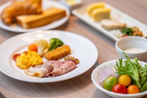 a wooden table with plates of food on it at Miyako Hotel Yokkaichi in Yokkaichi
