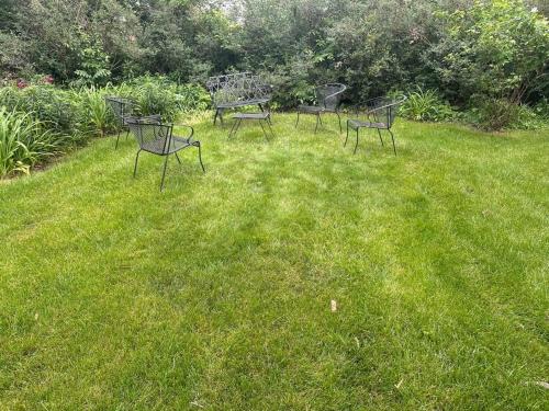 a group of benches sitting in the grass at House in the Park 5 Min from O'Hare in Des Plaines
