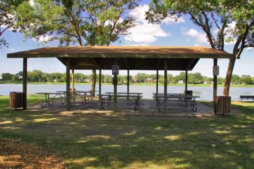 a pavilion with benches in a park next to a lake at House in the Park 5 Min from O'Hare in Des Plaines