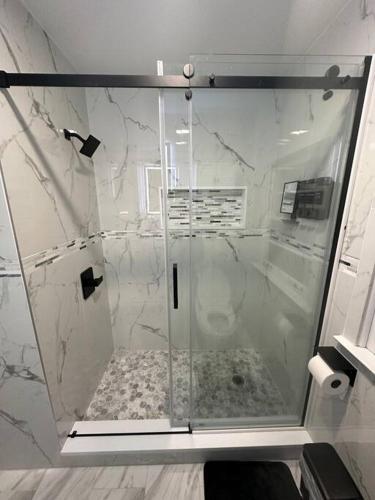 a shower with a glass door in a bathroom at House in the Park 5 Min from O'Hare in Des Plaines