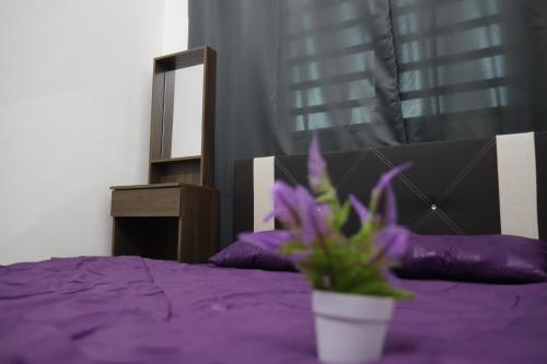 a purple bed with a potted plant on it at Homestay Az Zikri D' Sepat in Kuantan
