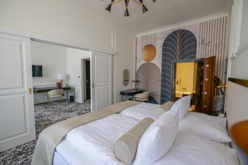 a bedroom with a large white bed and a desk at Hotel Zlatá Hvězda in Litomyšl