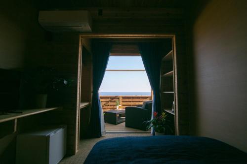 a bedroom with a mirror and a door with a window at LOGINNtarassoログインタラソ沖永良部島 in Wadomari