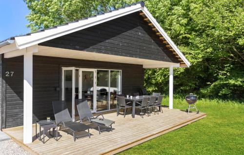 eine Holzterrasse mit einem Tisch und Stühlen darauf in der Unterkunft Beautiful Home In Tranekr With Wifi in Tranekær