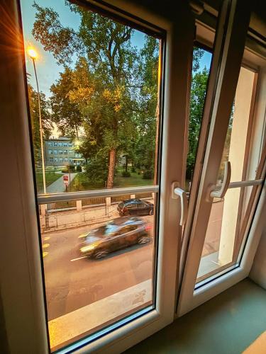 a window with a view of a car driving down a street at Polpo Apartments B&B in Łódź