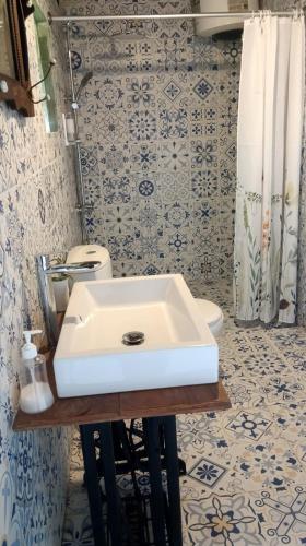 a bathroom with a white sink and a toilet at Pondok Beratan in Kawinaya in Gitgit