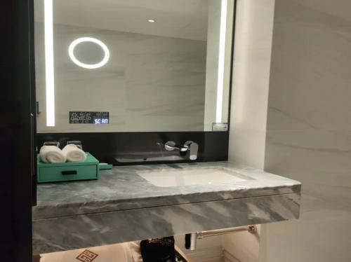 a bathroom counter with a sink and a mirror at Shu Guang International Hotel in Nanjing
