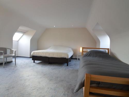 a bedroom with two beds and a chair at Villa in Zottegem with Pool and Sauna in Wolvenhoek