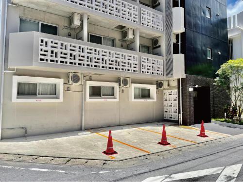 a building with orange traffic cones in front of it at Infinity Hotel NahaKumoji -SEVEN Hotels and Resorts- in Naha