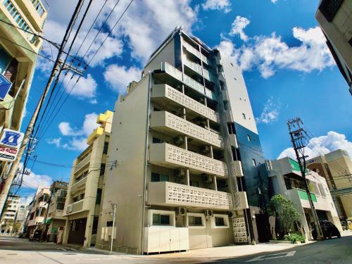 a tall building on the side of a street at Infinity Hotel NahaKumoji -SEVEN Hotels and Resorts- in Naha