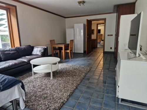 a living room with a couch and a table at Grand villa apartment 3 rooms in Trångsund