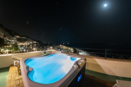 a blue bath tub on a balcony at night at Hotel Aurora in Amalfi
