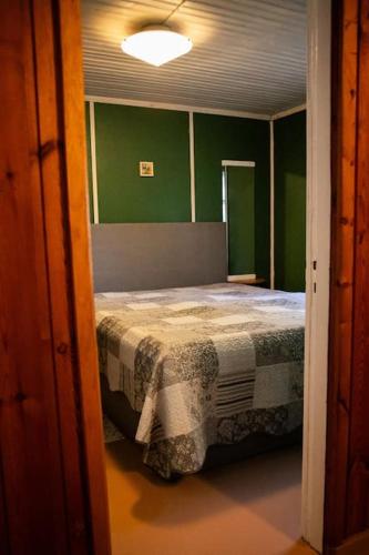 a bedroom with a bed in a room with green walls at Tõnise puhketalu in Rahuste