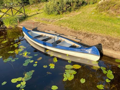 a blue and white boat sitting in the water at Haus Fågeläng in Hovmantorp