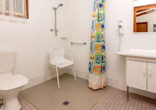 a bathroom with a toilet and a shower curtain at Echo Holiday Parks - Normanville in Normanville