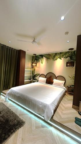 a bedroom with a large white bed with lights on it at Orsom Stays Sassy - Sector 42 in Gurgaon