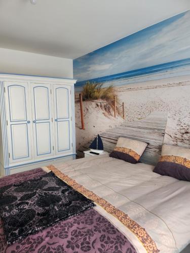 - une chambre avec une fresque murale représentant une plage dans l'établissement Maison proche mer, à Courseulles-sur-Mer