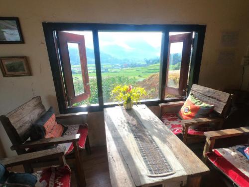 a room with a table and chairs and a large window at Amica House in Sa Pa