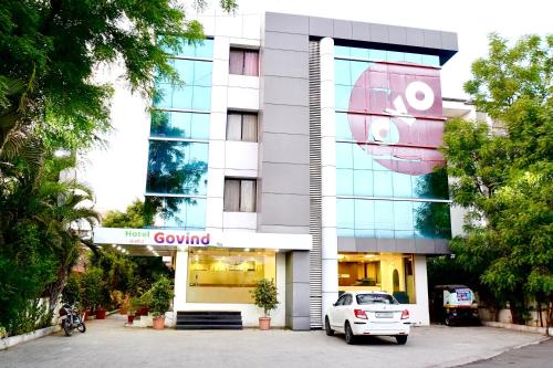 a white car parked in front of a building at Hotel Shri Govind in Shirdi