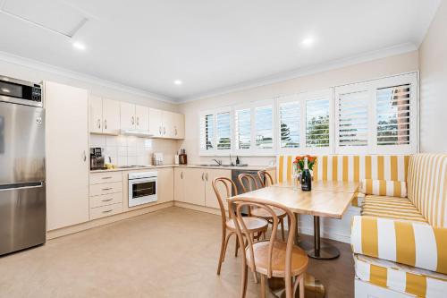 a kitchen with a table and chairs and a couch at bythesea - Oceanfront Living at Knights Beach in Port Elliot