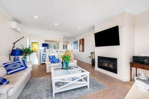 a living room with a couch and a fireplace at bythesea - Oceanfront Living at Knights Beach in Port Elliot
