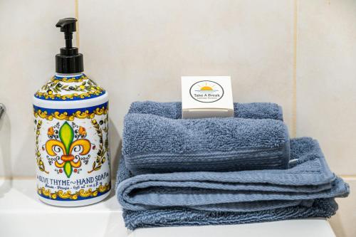 ポート・エリオットにあるbythesea-Beachfront cosy fireplace pet friendlyのシャンプーのボトルの横に青いタオルが積み重ねられている