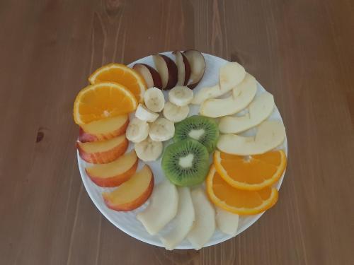 a plate of fruit on a wooden table at Paraskevi's Luxury Studios in Parga