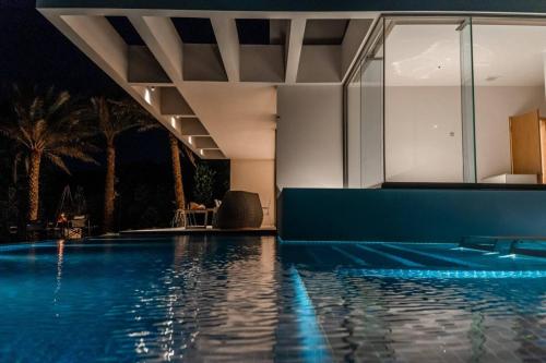 a swimming pool at night with the lights on the water at THE PANALI in Miyako Island