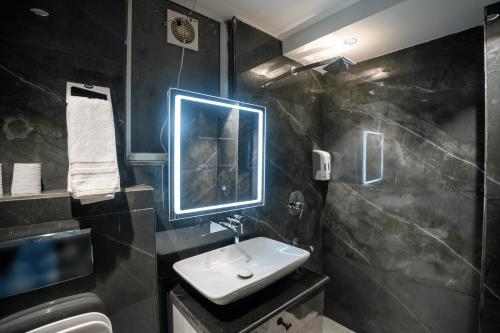 a bathroom with a sink and a mirror at Orsom Stays Sassy - Sector 42 in Gurgaon