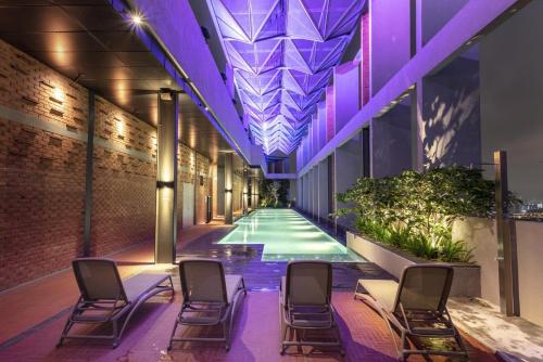 a swimming pool in the middle of a building with chairs at Millerz Square Old Klang Road in Kuala Lumpur