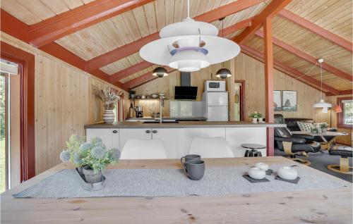 a kitchen and living room with a table in a room at Holiday Home Blåvand With Fireplace Vi in Blåvand