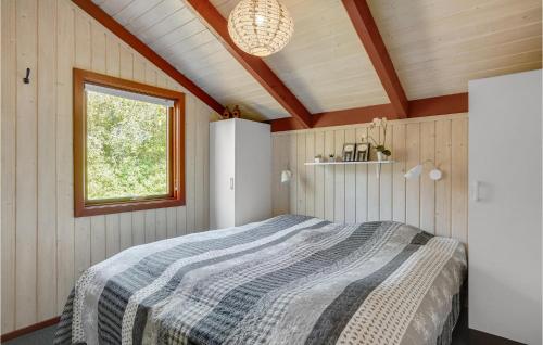 a bedroom with a bed in a room with a window at Holiday Home Blåvand With Fireplace Vi in Blåvand