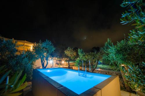 a swimming pool in a backyard at night at Villa Buon Vento in Vignacastrisi
