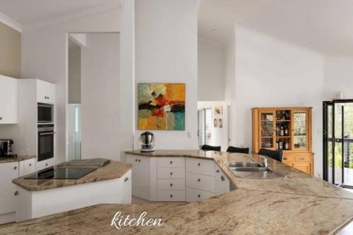 a large kitchen with white cabinets and a sink at Hideaway at Brookfield Acreage Tennis Court Pool in Brookfield