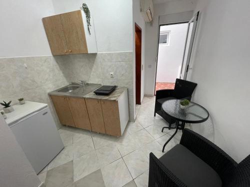 a small kitchen with a sink and a table at Apartments Pericic in Sutomore