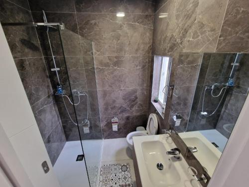 a bathroom with a shower and a sink and a toilet at Sky Apartment 3 in St Paul's Bay