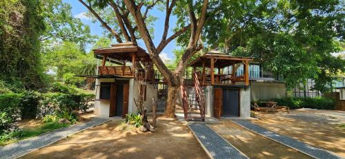 a tree house with a ladder in front of it at Seven 50s in Pai