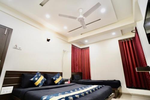 a bedroom with two beds and a ceiling fan at Hotel Shri Govind in Shirdi