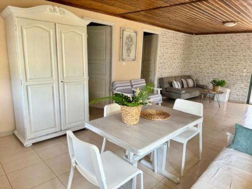 a living room with a table and chairs and a couch at Menƴ's Azure Escape in Dhíkella