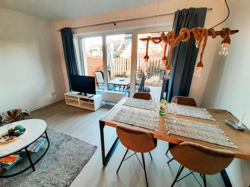 Una sala de estar con una mesa y sillas y un televisor. en Ferienhaus Auen, en Maasholm