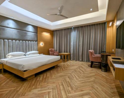 a bedroom with a bed and a desk and chairs at Comfort Inn in Lucknow