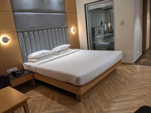 a bedroom with a large white bed in a room at Comfort Inn in Lucknow