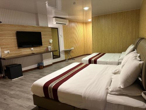 a hotel room with two beds and a flat screen tv at S.S.HOTEL SEREMBAN in Seremban
