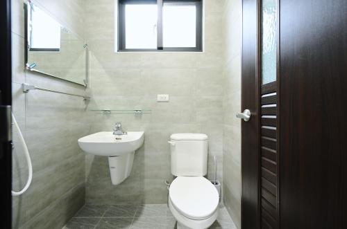 a bathroom with a toilet and a sink at 谷園酒店公寓Good Garden Apartment in Taichung